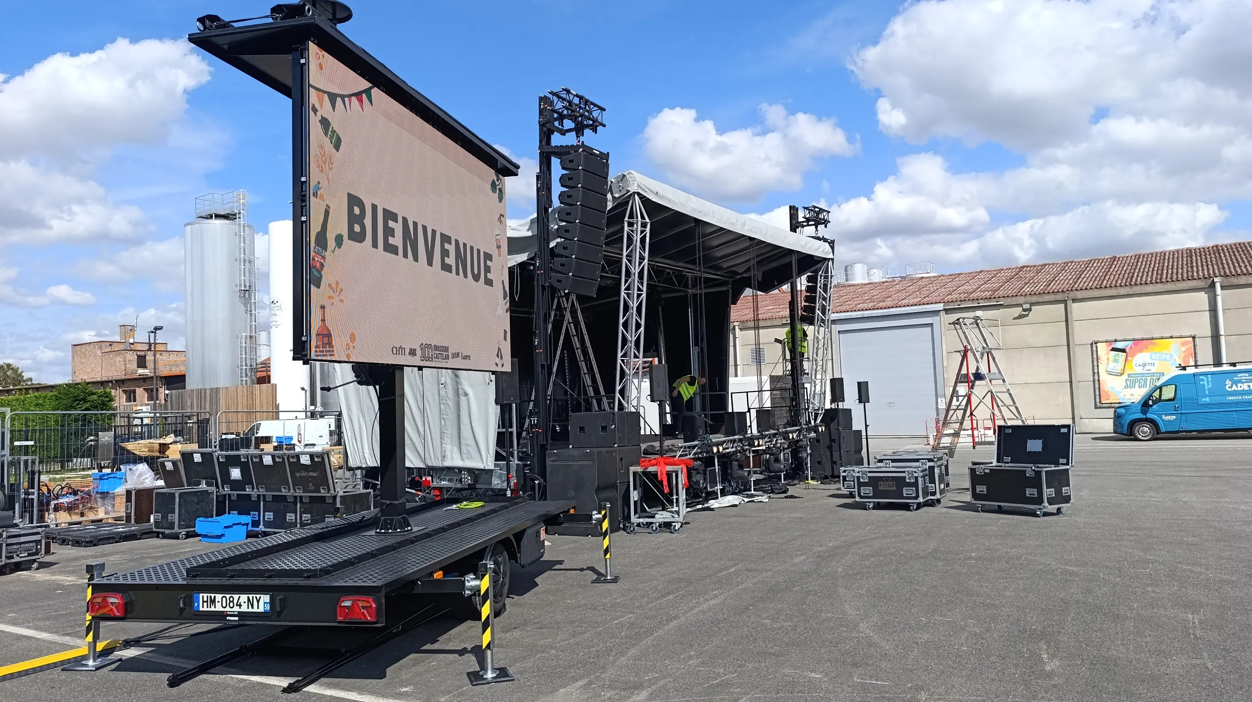 Remorque avec écran LED levé et stabilisateurs déployés, installée à côté d’une scène extérieure.